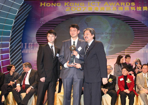 Mr. Li Mo (left) and Dr. Liu Yun-hao (center) received the Grand Award Trophy from the Financial Secretary John C Tsang at the Award Presentation Ceremony.